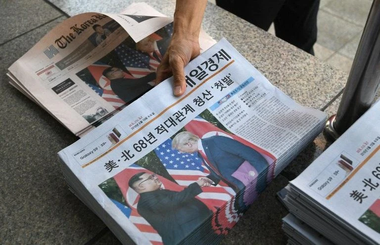 A South Korean newspaper deliveryman collects newspapers in Seoul reporting the summit between US President Donald Trump and North Korean leader Kim Jong Un on June 12, 2018. (File/AFP)
