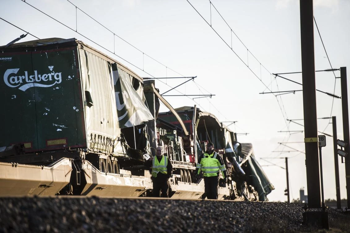 People walk near damaged cargo compartments on a train parked near the Storebaelt bridge, near Nyborg in Denmark, Wednesday, Jan. 2, 2019. (Tim K. Jensen/Ritzau Scanpix/AP)
