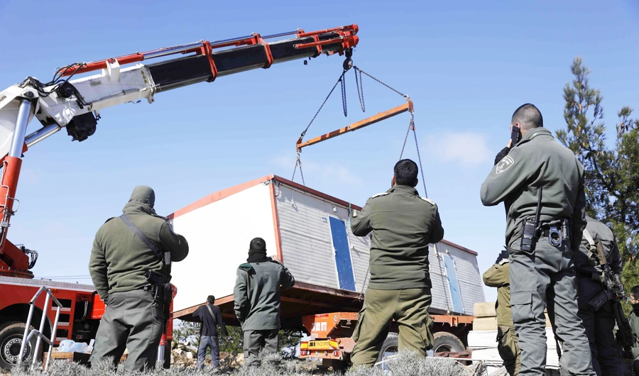 Israeli security forces remove a caravan belonging to the illegal settlers on Thursday from the former outpost in the occupied West Bank. (AFP)