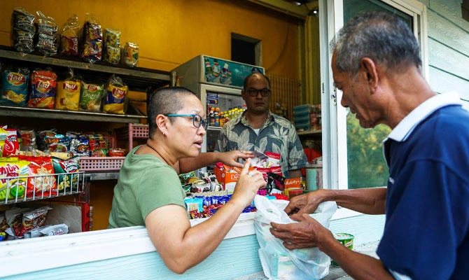 Boodsabann Chanthawong works with her husband at her stall near her house, days after she ended her novice monkhood, at the Songdhammakalyani monastery, in Bangkok, Thailand, December 16, 2018. (REUTERS)