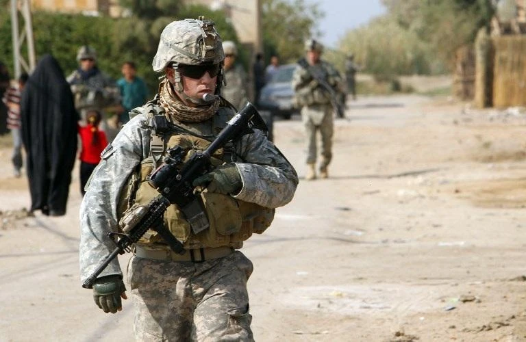A US soldier stands guard near a school in the town of Iskandiriyah in Iraq's Babel province. (File/AFP)