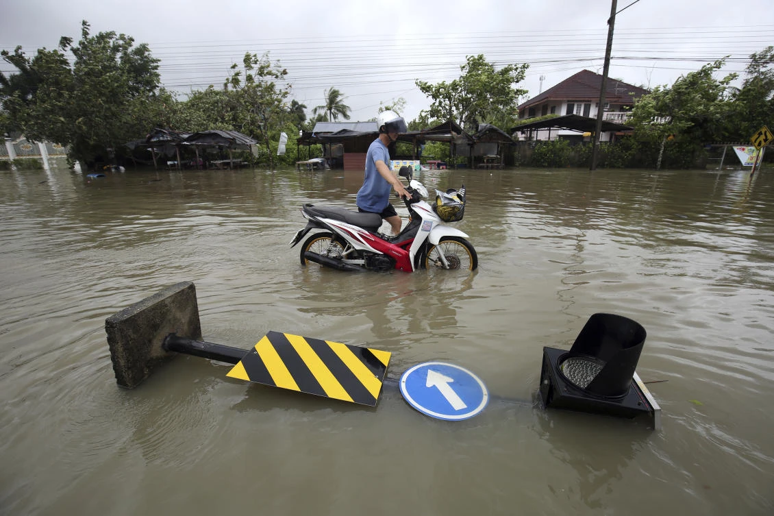 A resident pushes his motorcycle through floodwater from Tropical Storm Pabuk on Friday, January 4, 2019, in Pak Phanang of southern Thailand. (AP)