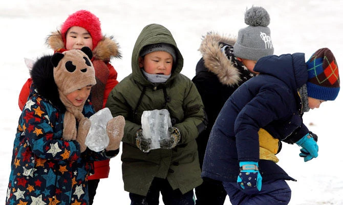 Children play with ice on Songhua River that displays 2019 snowmen as a part of annual ice festival, in the northern city of Harbin, Heilongjiang province, China January 4, 2019. (REUTERS)