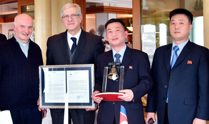 This March 20, 2018 photo made available Thursday, Jan. 3, 2019 by the Parish of Farra di Soligo, shows North Korea's acting ambassador to Italy Jo Song Gil, second from right, holding a model of "Bell of Peace of Rovereto" during a cultural event on the occasion of a visit of the North Korean delegation to the Veneto region, in San Pietro di Feletto, near Treviso, northern Italy. (AP)