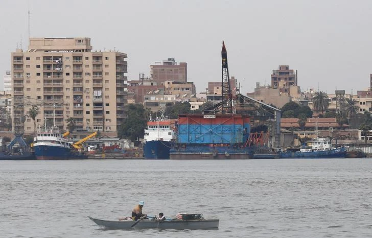 Fishermen travel on a boat in front of a container ship in the Suez canal at Ismailia port city, northeast of Cairo, Egypt February 27, 2017. (Reuters)