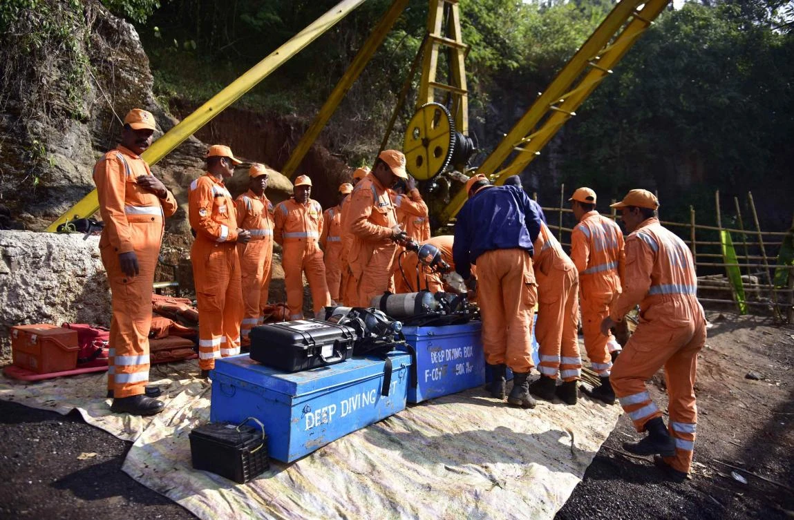 Indian Navy and NDRF personnel went inside a 370-foot-deep mine, where 15 miners are trapped, to ascertain the water level inside. (AFP)