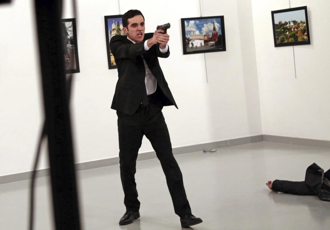 Mevlut Mert Altintas, an off-duty policeman, shouts after shooting Andrei Karlov, right, the Russian ambassador to Turkey, at an art gallery in Ankara, Turkey. (AP/Burhan Ozbilici)