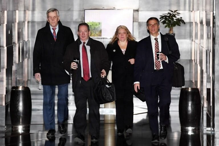 Members of the US negotiation team leave a hotel for the second day of talks in Beijing, seeking to resolve a number of thorny issues that have threatened an all-out trade war between the world’s two biggest economies. (AFP)