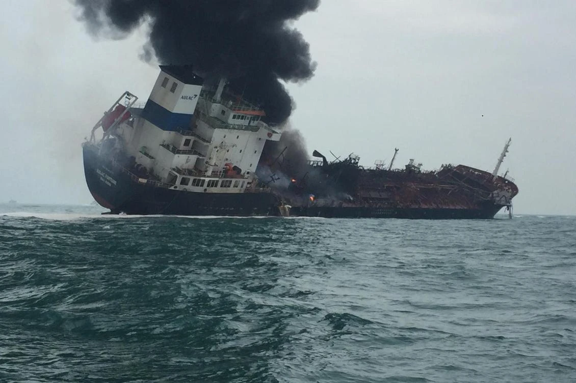 A photo from the Hong Kong Police shows smoke rising from an oil tanker as it tilts to one side. (Hong Kong Police/AFP)