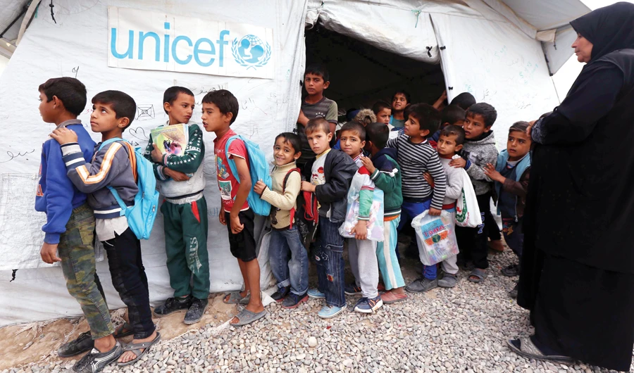Iraqi children from the former embattled city of Mosul queue up outside a United Nations Children’s Fund school some 40 km east of Irbil. (AFP)