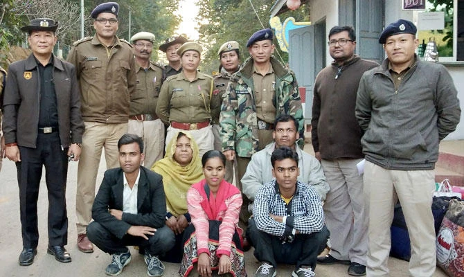 Members of a Muslim Rohingya family sit as they pose for a photograph with Indian and Myanmar security officials before their deportation on India-Myanmar border at Moreh in the northeastern state of Manipur, India, January 3, 2019. (REUTERS)