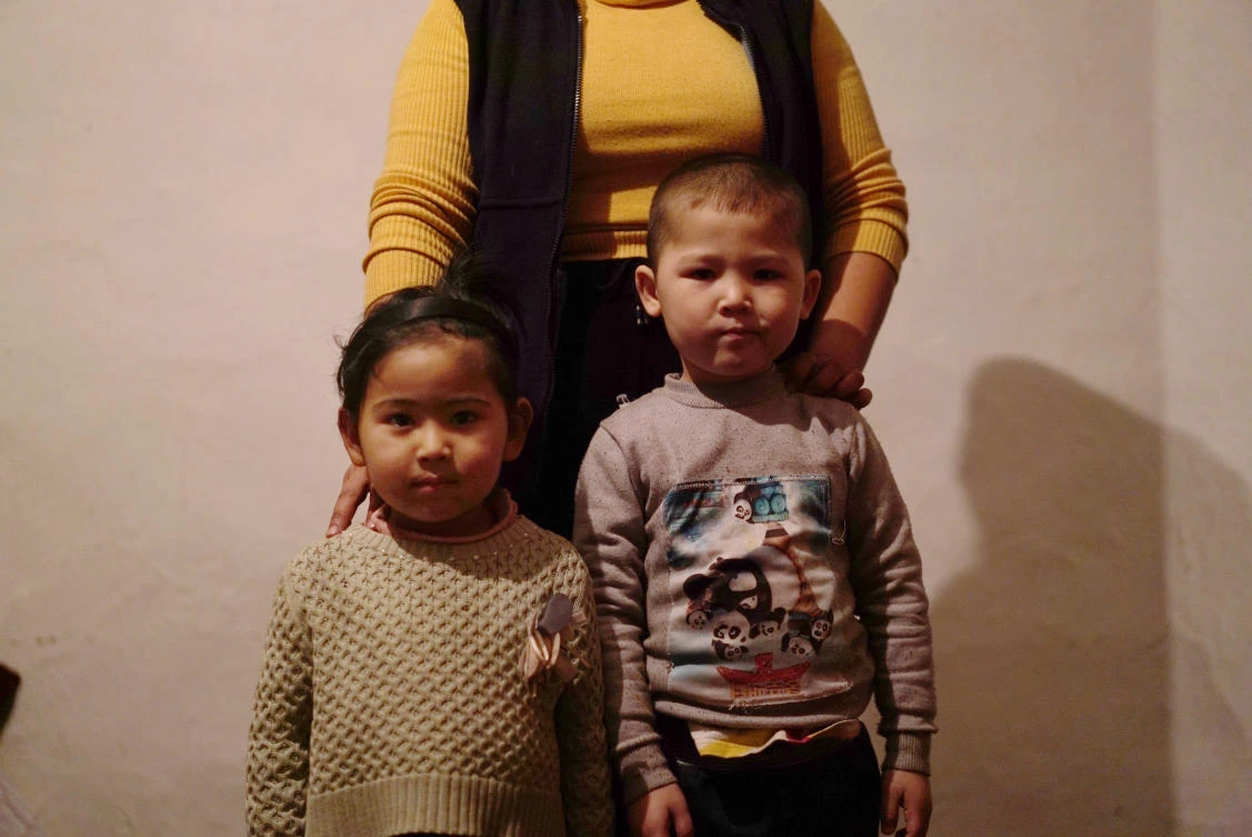 A 23-year-old Kazakh citizen who asked to be identified by her nickname, Guli, to protect her family from retribution, stands with her children at their home in a village near Almaty, Kazakhstan. (AP/Dake Kang)