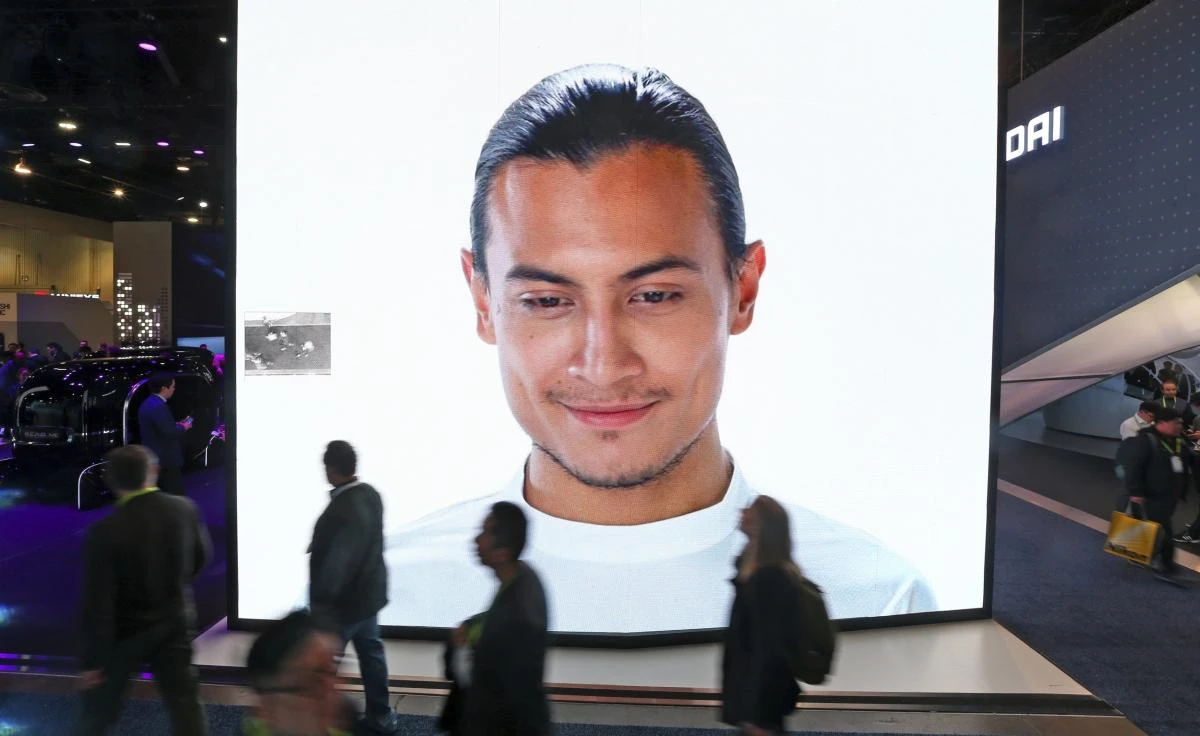 A giant KIA video screen advertises facial recognition in prototype vehicles as patrons walk past at CES International Wednesday, Jan. 9, 2019, in Las Vegas. (AP/Ross D. Franklin)
