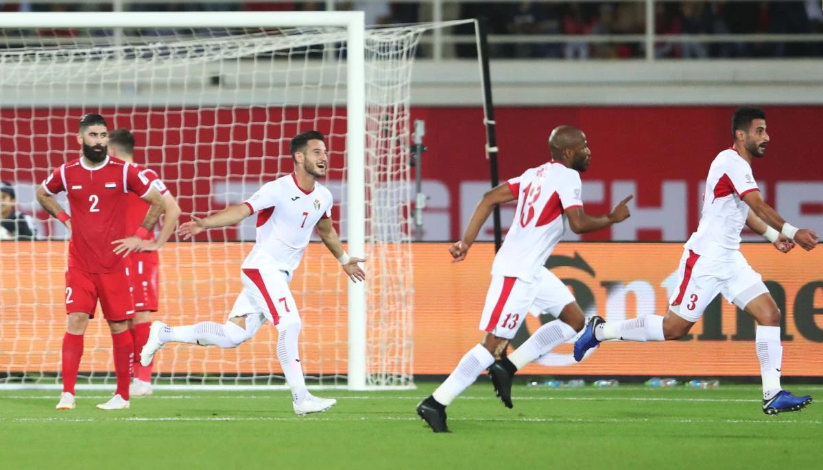 Jordan’s Tareq Khattab celebrates scoring their second goal against Syria with Yousef Al-Rawashdeh and Khalil Bani Ateyah. (Reuters)