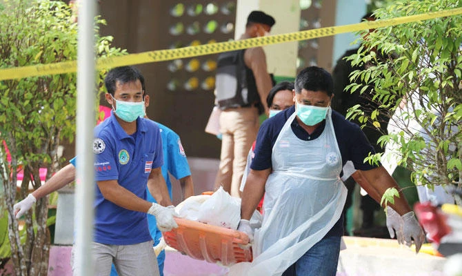 Paramedics take away a body after four Thai civil defence volunteers were shot and killed outside of a school in the restive southern province of Pattani on January 10, 2019. (AFP)