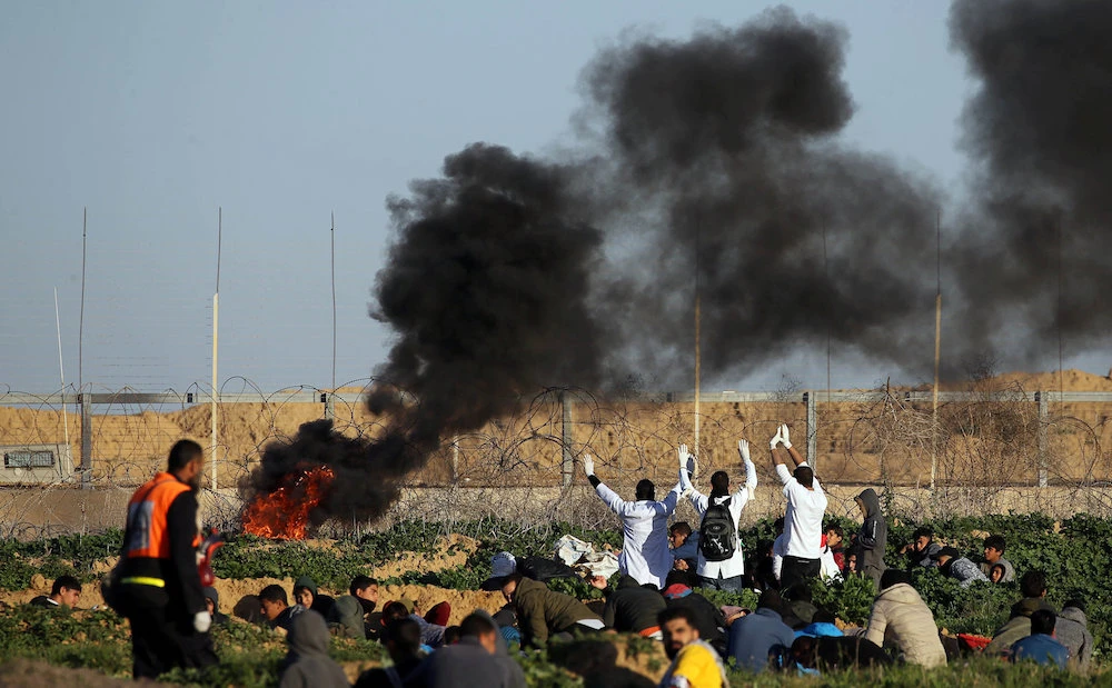 Palestinian medics raise up their hands as they try to evacuate a wounded demonstrator during protest at the Israel-Gaza border fence, in the southern Gaza Strip January 11, 2019. (Reuters)
