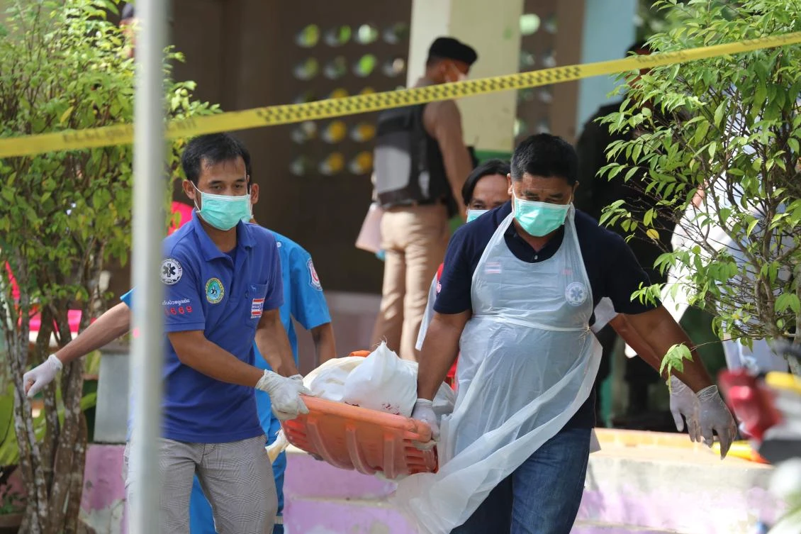 Paramedics take away a body after four Thai civil defense volunteers were shot and killed by suspected insurgents outside of a school in the southern province of Pattani on January 10. (AFP)