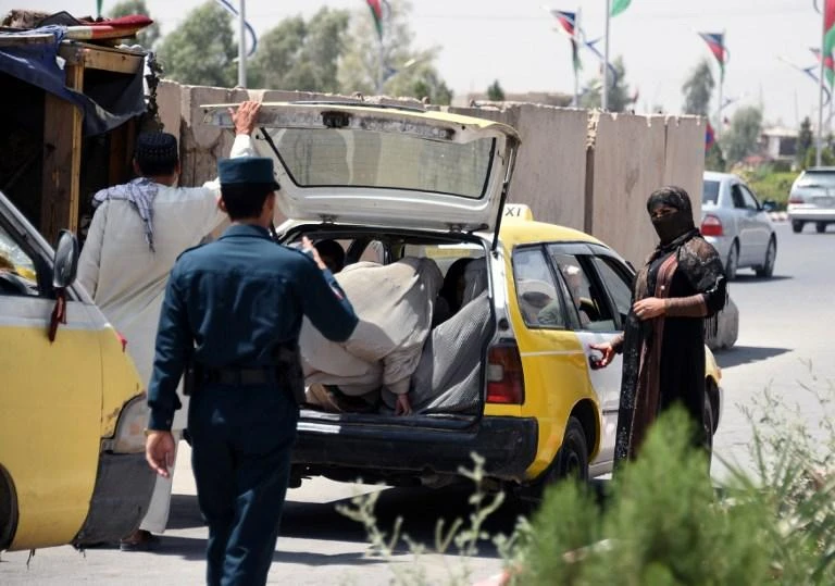 Afghan policemen search passengers at a checkpoint in Kandahar on October 18, 2018. (AFP)