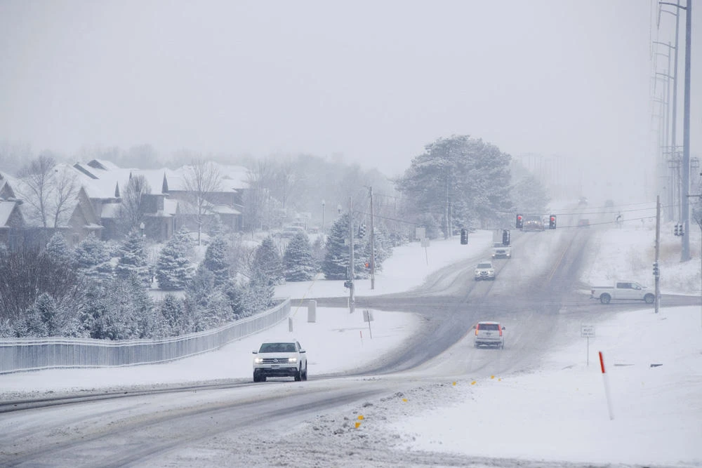 Traffic moves along Pacific Street near its intersection with 189th Street as snow falls in Omaha, Nebraska, on Jan. 12, 2019. (Ryan Soderlin/Omaha World-Herald via AP)