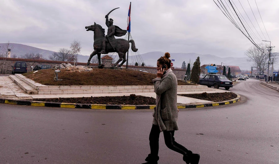 A Kosovo Serb woman walks past a statue in the town of Gracanica near Pristina on December 29, 2018. (AFP / Armend Nimani)
