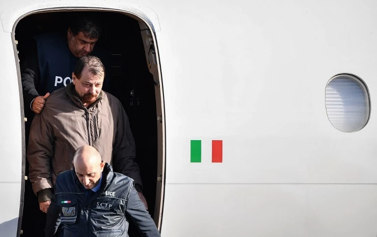Fugitive Cesare Battisti, center, wanted in Rome for four murders attributed to a far-left group in the 1970s, is escorted by Italian officers as he steps off a plane coming from Bolivia. (AFP)