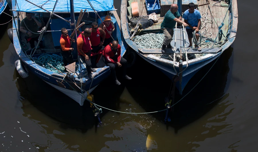 Firefighters tow an underwater police helicopter that crashed into Guanabara Bay. (AP)