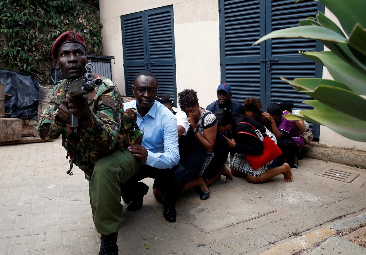 People are evacuated by a member of security forces at the scene of the attack. (Reuters)
