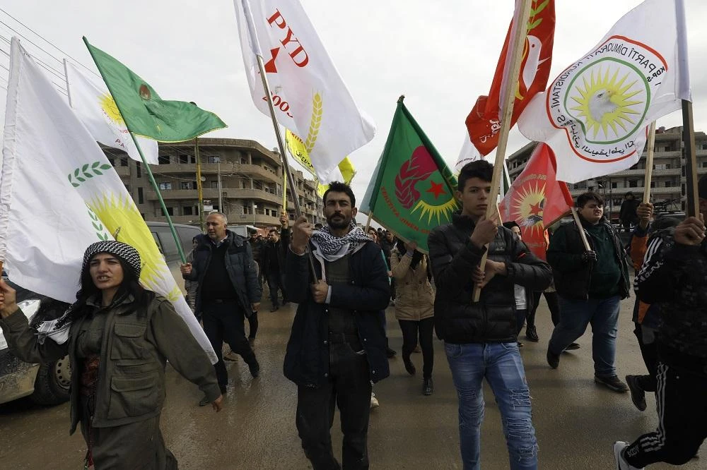 Syrian Kurdish protesters wave flags during a demonstration in the northeastern Syrian Kurdish-majority city of Qamishli on December 28, 2018. (AFP)