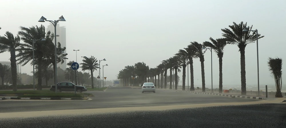 A car drives through a sandstorm along the Gulf Road in Kuwait City on March 12, 2014. (File/AFP)