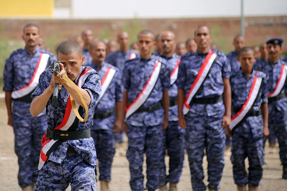 A Yemeni aims his rifle as fighters from the Popular Resistance Committees, supporting forces loyal to the Yemen's Saudi-backed government, attend a graduation ceremony in the country's third city Taiz, on July 17, 2018. (File/AFP)
