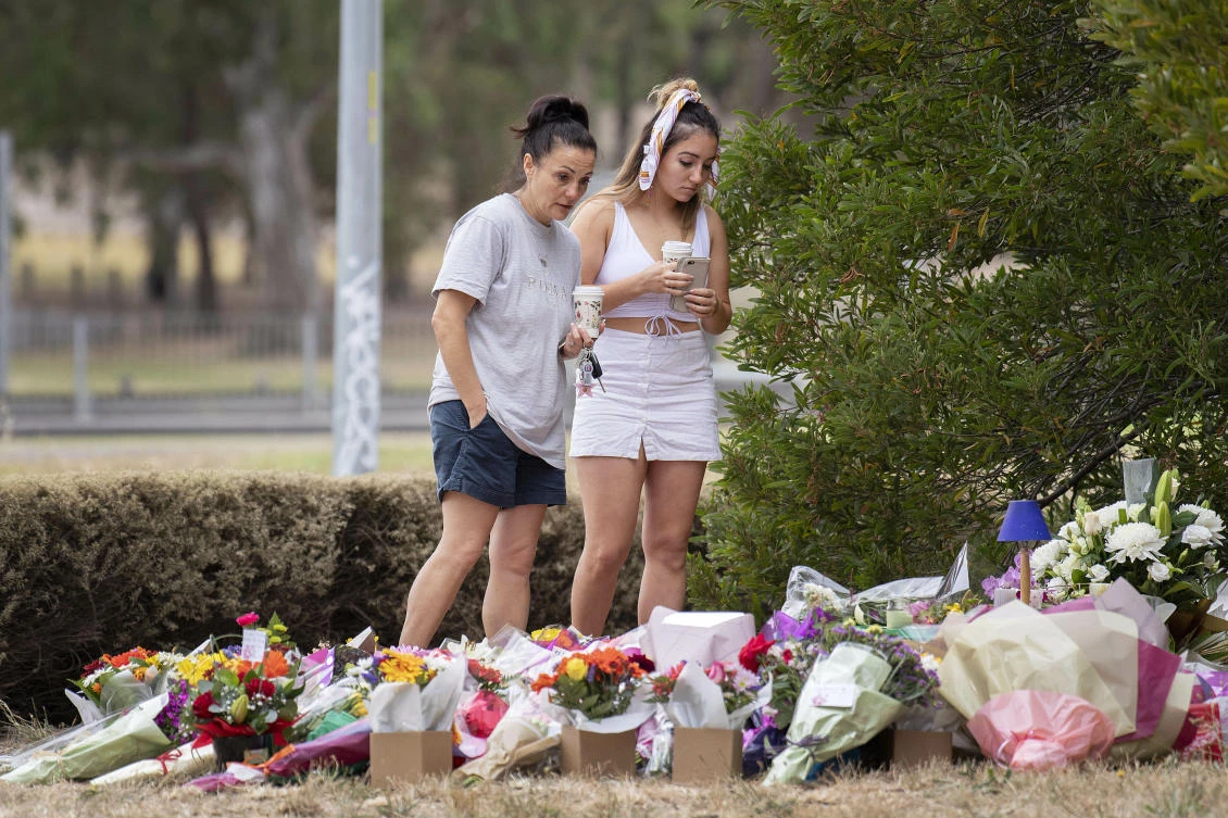 Two women stand at a floral tribute at the scene where the body of Israeli student Aiia Maasarwe was found earlier in the week in Melbourne, Australia. (AP)