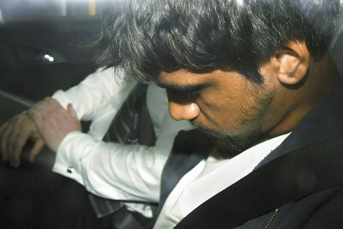 An unnamed suspect sits in a police car after he was arrested for questioning over the death of Israeli student Aiia Maasarwe in Melbourne. (AAP Image via AP)