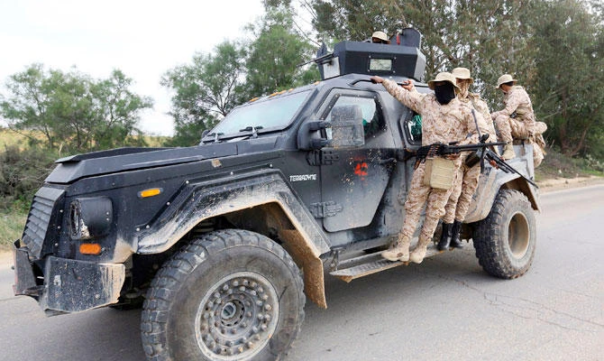 Members of the Tripoli Protection Force, an alliance of militias from the capital city, patrol an area south of the Libyan capital on January 18, 2019, during clashes with the Seventh Brigade group from the town of Tarhuna. (AFP)