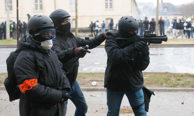 A police officer aims after a yellow vest march Saturday, Jan. 19, 2019 in Paris. (AP)