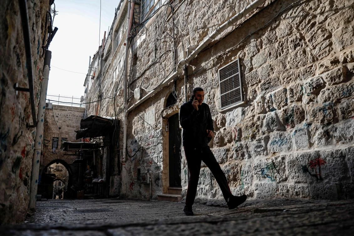 A man walks past a house in the Muslim Quarter of the Old City of Jerusalem which was bought by Israeli settlers. (AFP)