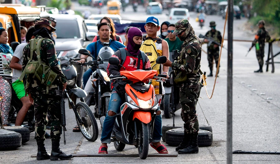 Security forces check identification at a checkpoint in Cotabato on the southern Philippine island of Mindanao on January 20, 2019, a day before a vote on giving the nation's Muslim minority greater control over the region. (AFP / Noel Celis)