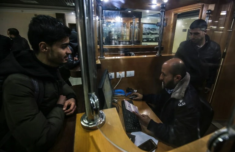 The funds will cover salaries of around 40,000 Hamas civil servants. Above, a Hamas police officer checks documents at the Rafah border crossing in Gaza. (AFP)