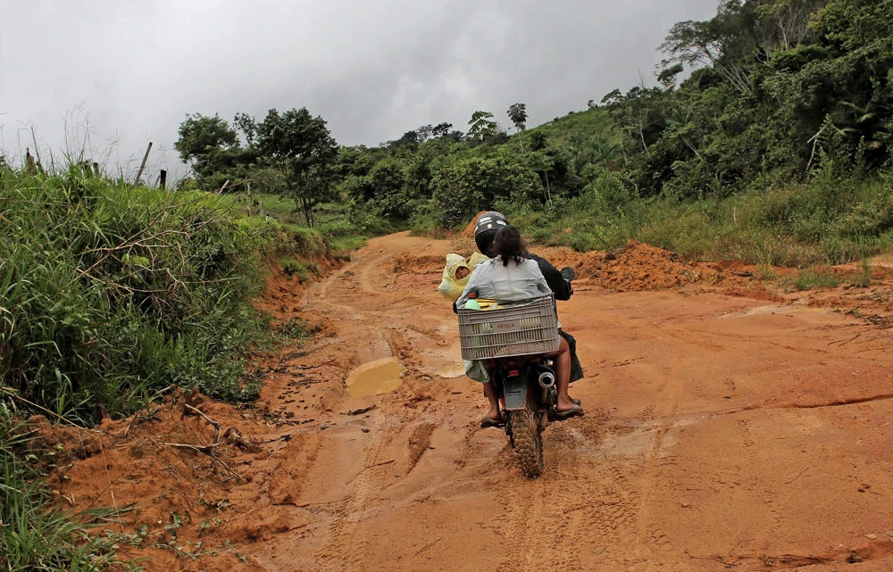 A family rides their motorcycle along the Trans-Amazonian highway near the city of Uruara, Para state. (REUTERS/Nacho Doce/File Photo)