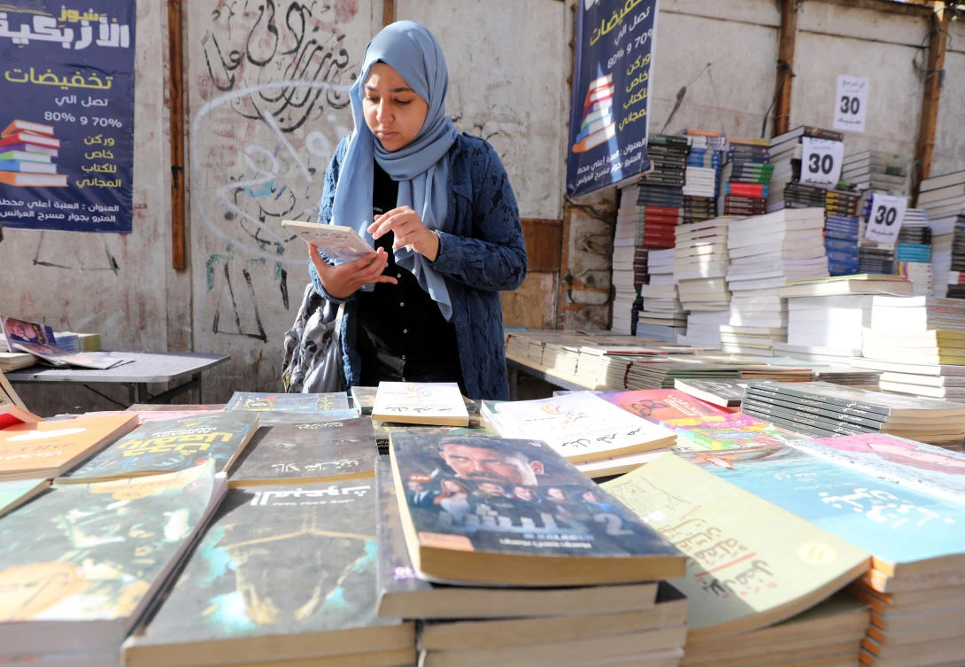 A woman checks a book at the historic Al-Azbakeya book market in Cairo, Egypt January 15, 2019. (Reuters)