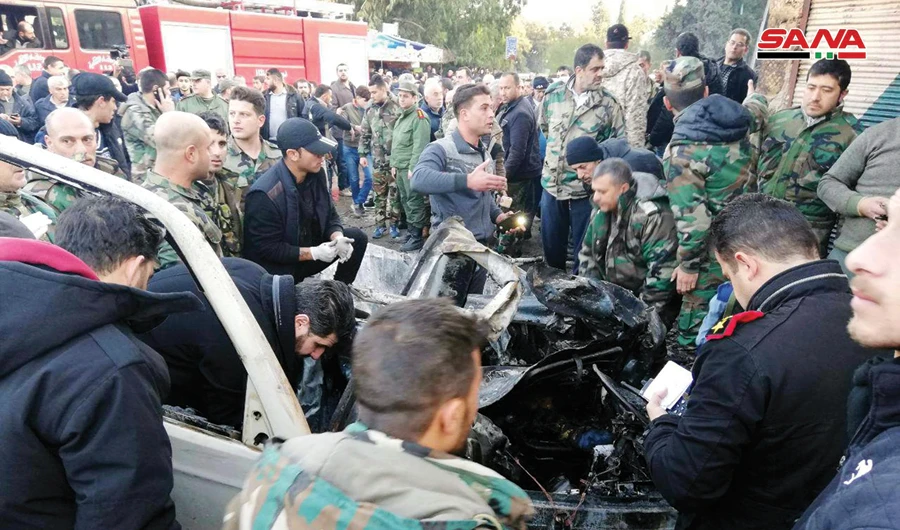 Syrian security forces inspect a burned car at the site of an explosion in Latakia, near President Bashar Assad’s ancestral village, on Tuesday. (AP)