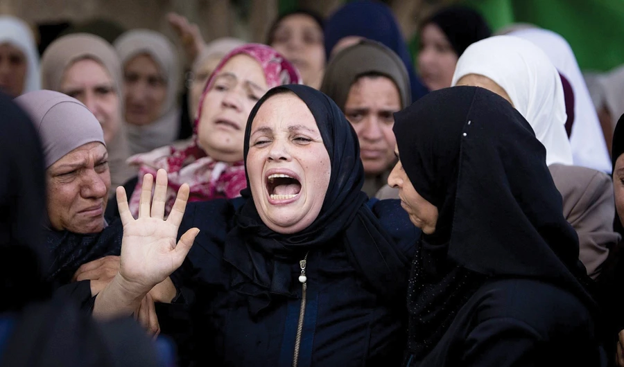 Relatives of Aisha Rabi mourn at the family home during her funeral in the West Bank village of Biddya, on Oct. 13. (AP)