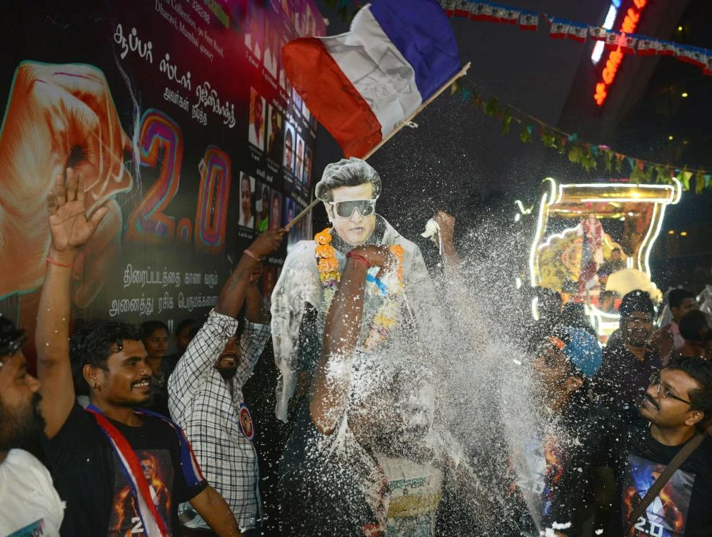 Fans spray milk on a placard displaying the picture of Bollywood actor Rajinikanth, the biggest star in the history of Tamil-language cinema, before attending the first-day release his new Tamil-language film ‘2.0’ in Mumbai. (AFP)
