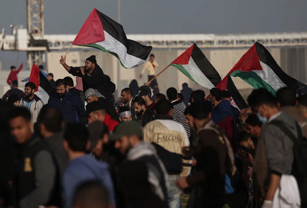 Palestinians carry national flags during a demonstration along the border with Israel, east of Gaza City on January 25, 2019. (AFP)