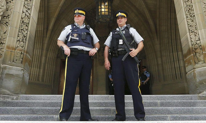 Royal Canadian Mounted Police (RCMP) officers stand guard at the base of the Peace Tower on Parliament Hill in Ottawa May 27, 2015. (REUTERS)