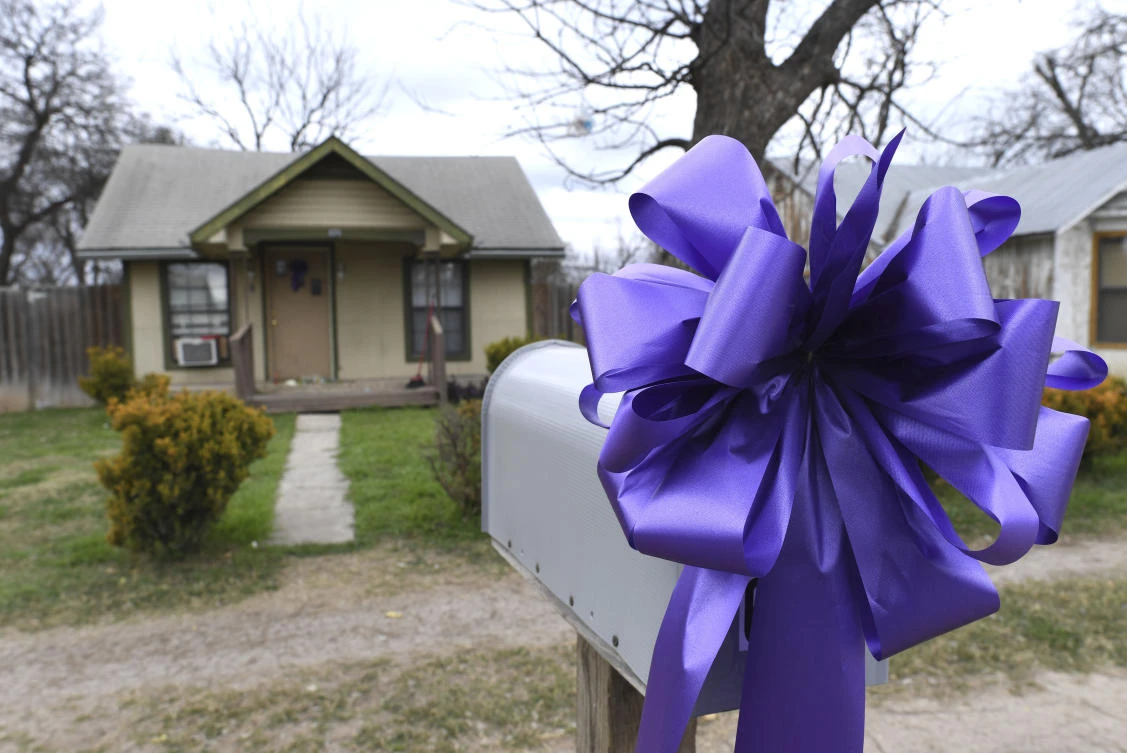 A purple ribbon is displayed on the mailbox of a home here boxer John Duane VanMeter was shot and killed on Wednesday night, January 24. (The San Antonio Express-News via AP)