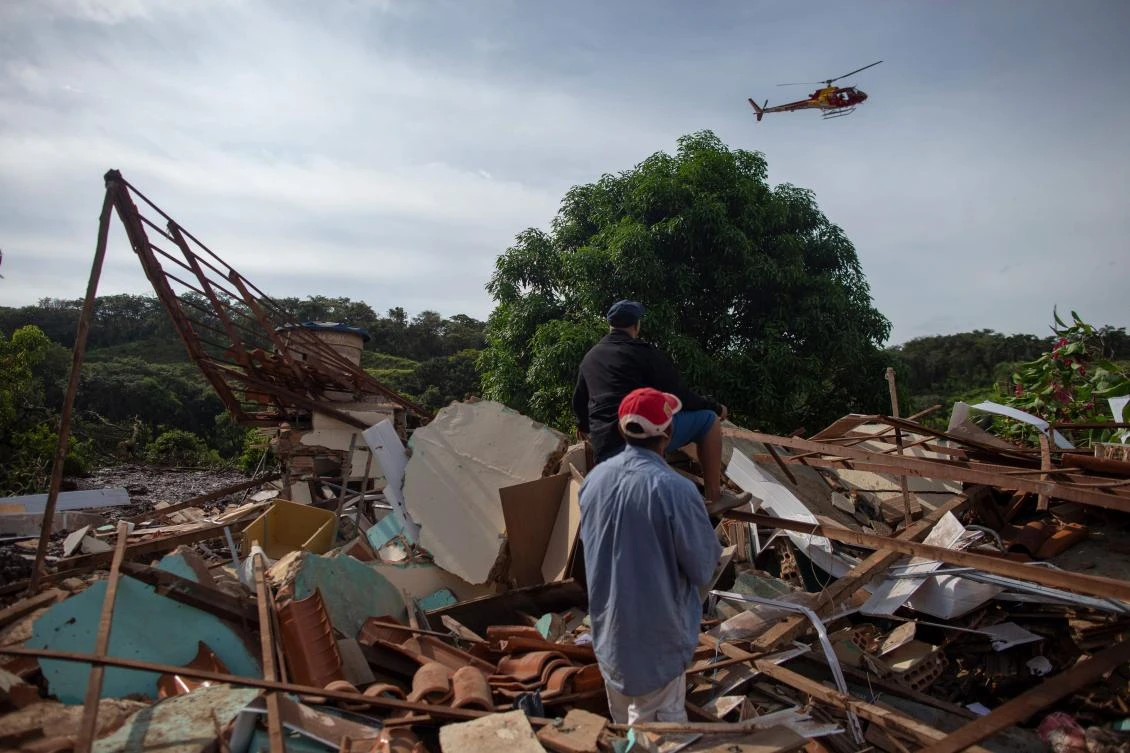 A firefighter helicopter flies over a mud-hit area of Brazil a day after the collapse of a dam belonging to mining company Vale. (AFP)