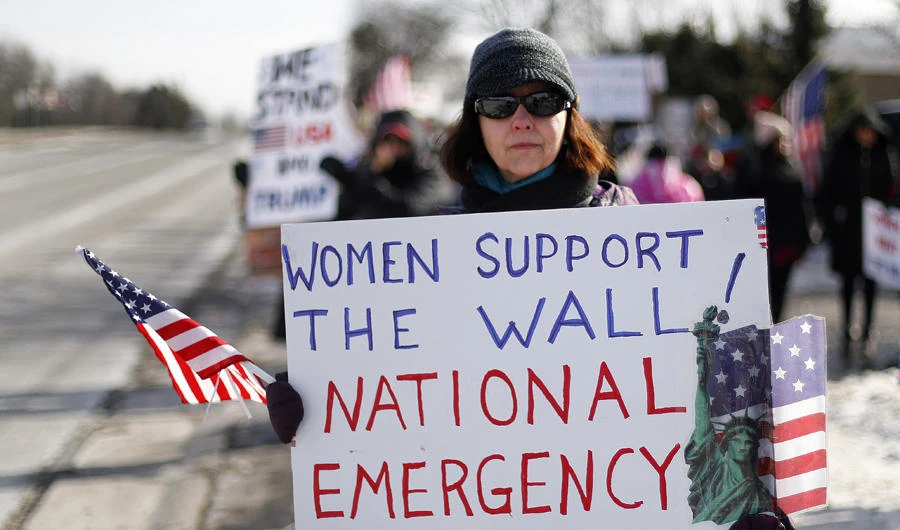 A supporter holds a sign at a women for Trump "Build the Wall" rally in Bloomfield Hills, Michigan, US, on Jan. 26, 2019. (AP Photo/Paul Sancya)