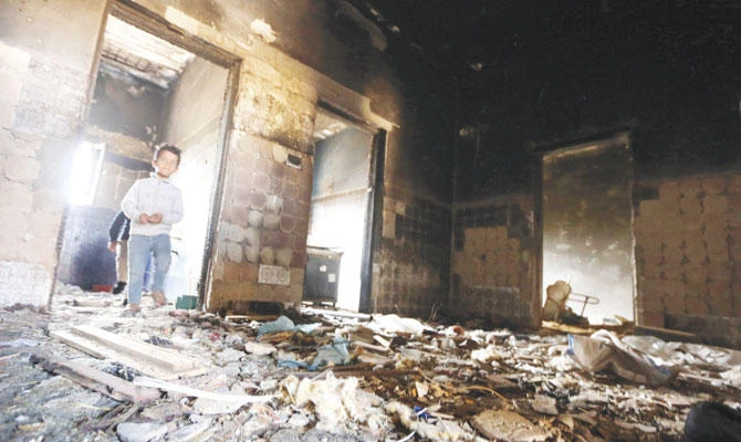 A Libyan boy walks in a burned and destroyed building in the town of Al-Gawalesh, 120 km west of the capital Tripoli. (AFP)