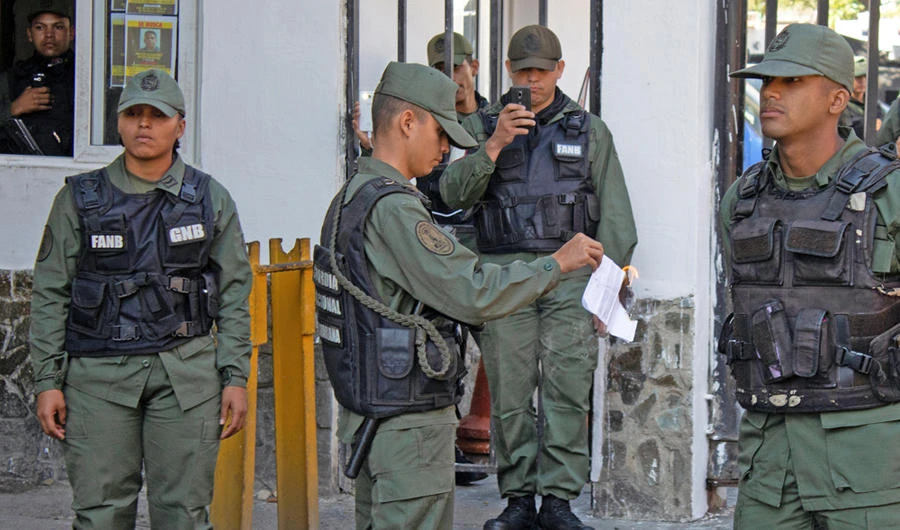 A Venezuelan National Guard sets on fire a copy of a document on a proposed amnesty law for members of the military, police and civilians, which was presented by supporters of Venezuelan opposition leader Juan Guaido outside a military unit in Caracas, Venezuela, on January 27, 2019. (Ronald Pena/El Pitazo via REUTERS)