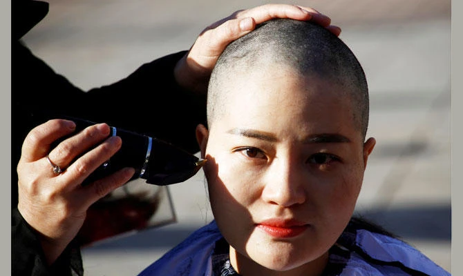 Li Wenzu, the wife of prominent Chinese rights lawyer Wang Quanzhang, has her head shaved in protest over the government's treatment of her husband in Beijing, China, December 17, 2018. (REUTERS)